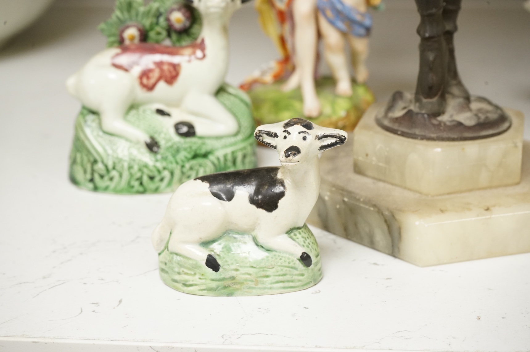 An Art Deco resin and patinated spelter model of a dancer on onyx base, two late 18th century Staffordshire coloured creamware recumbent cows and a spongeware deer, a WWI commemorative teapot with ‘For Right and Freedom’